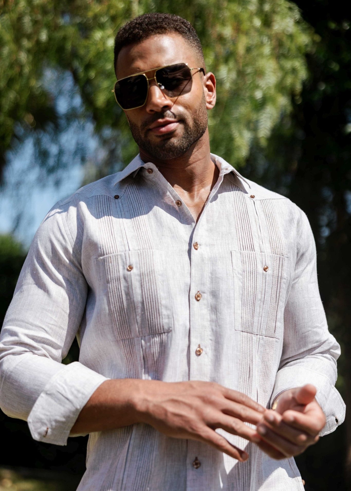 Man wears the light grey Men’s 100% Linen Guayabera Shirt, long sleeve with heritage pleats detail.