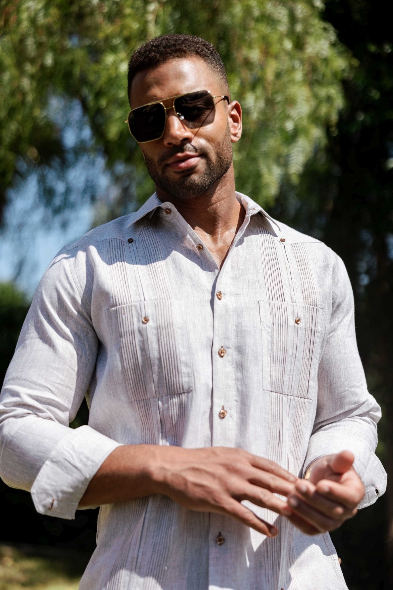 Man wears the light grey Men’s 100% Linen Guayabera Shirt, long sleeve with heritage pleats detail.