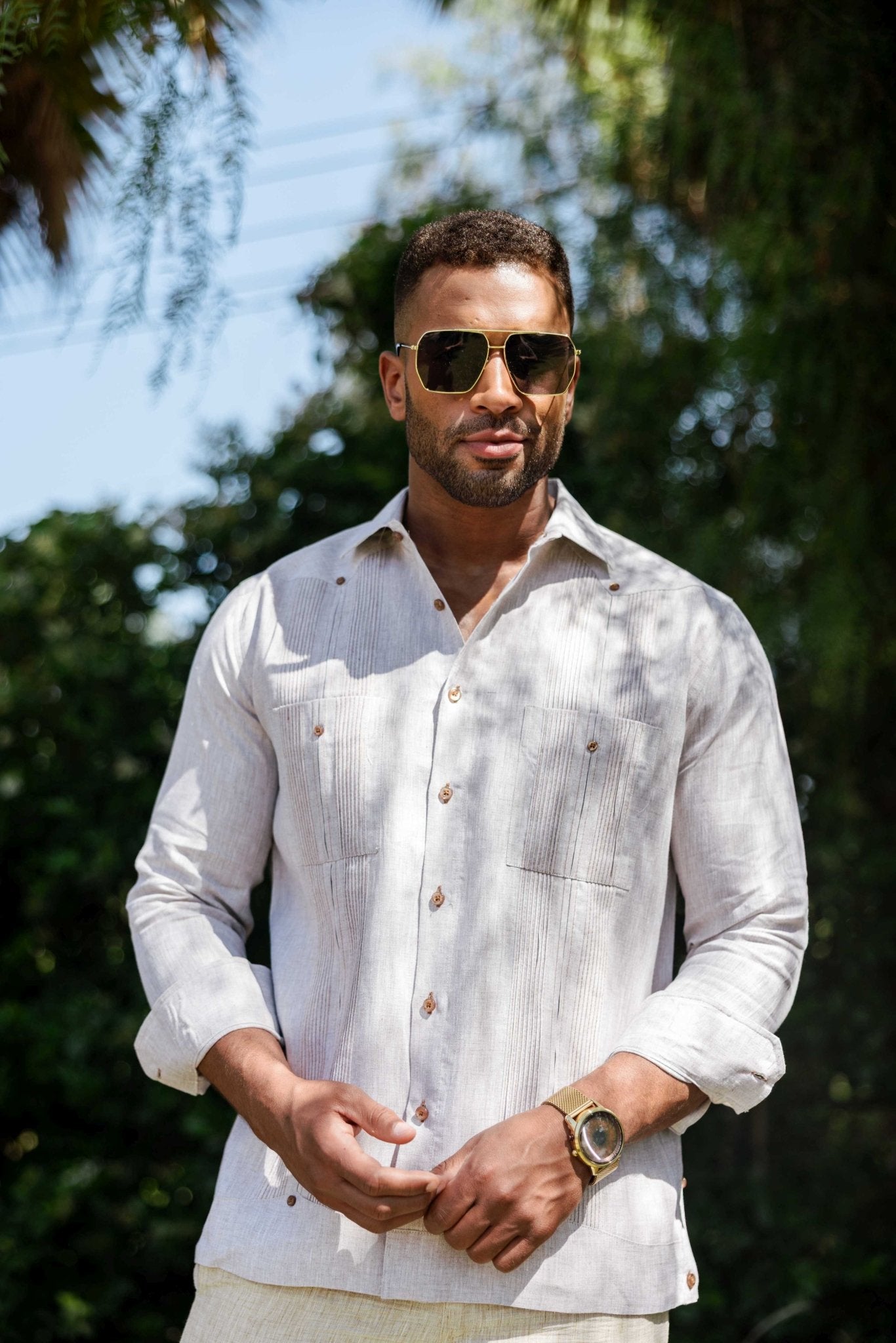A man wears an off-white long-sleeve Men’s 100% Linen Guayabera Shirt with heritage pleats.