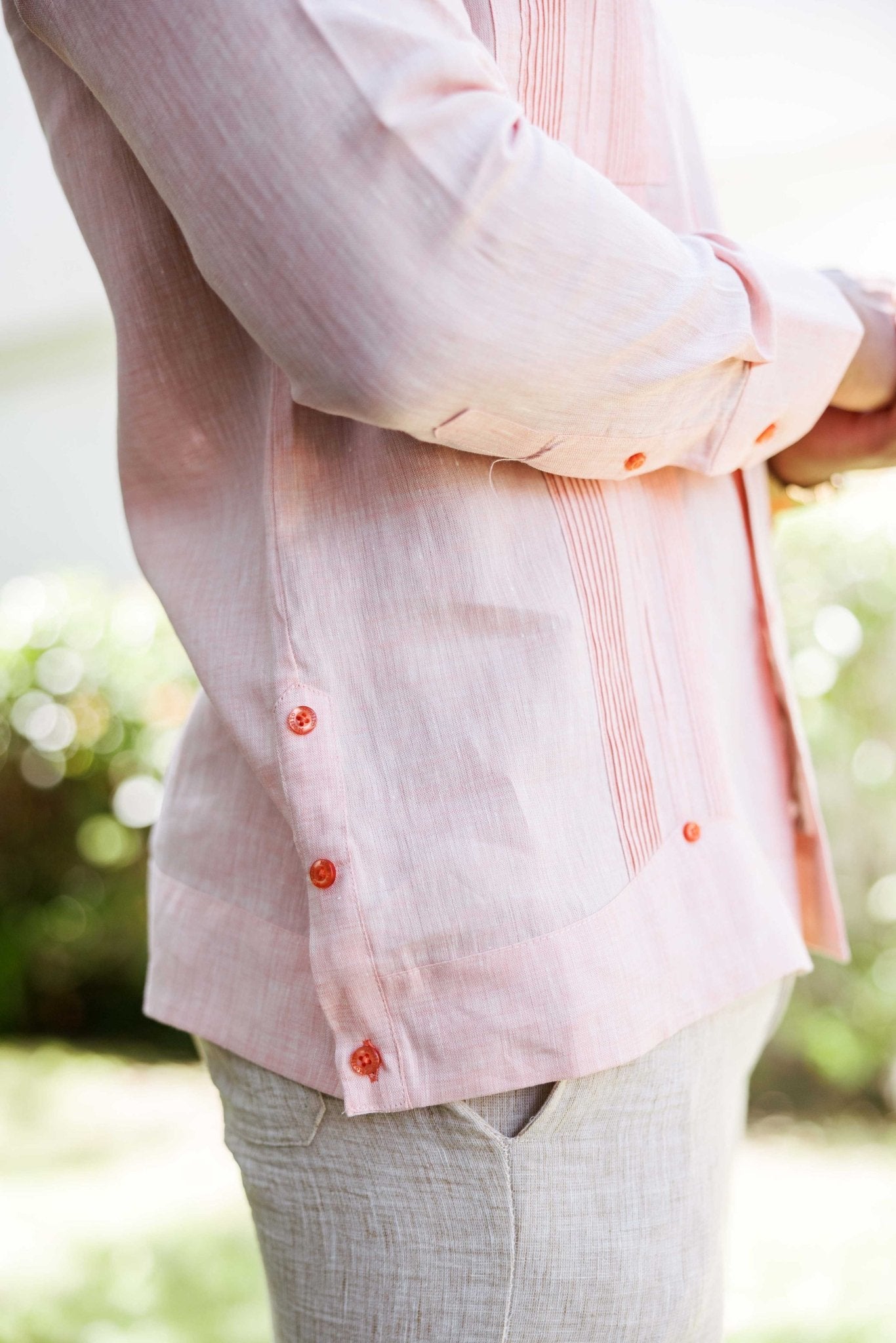 Side view of a light pink Men’s 100% Linen Guayabera Shirt showing sleeve, buttons, and heritage pleats.