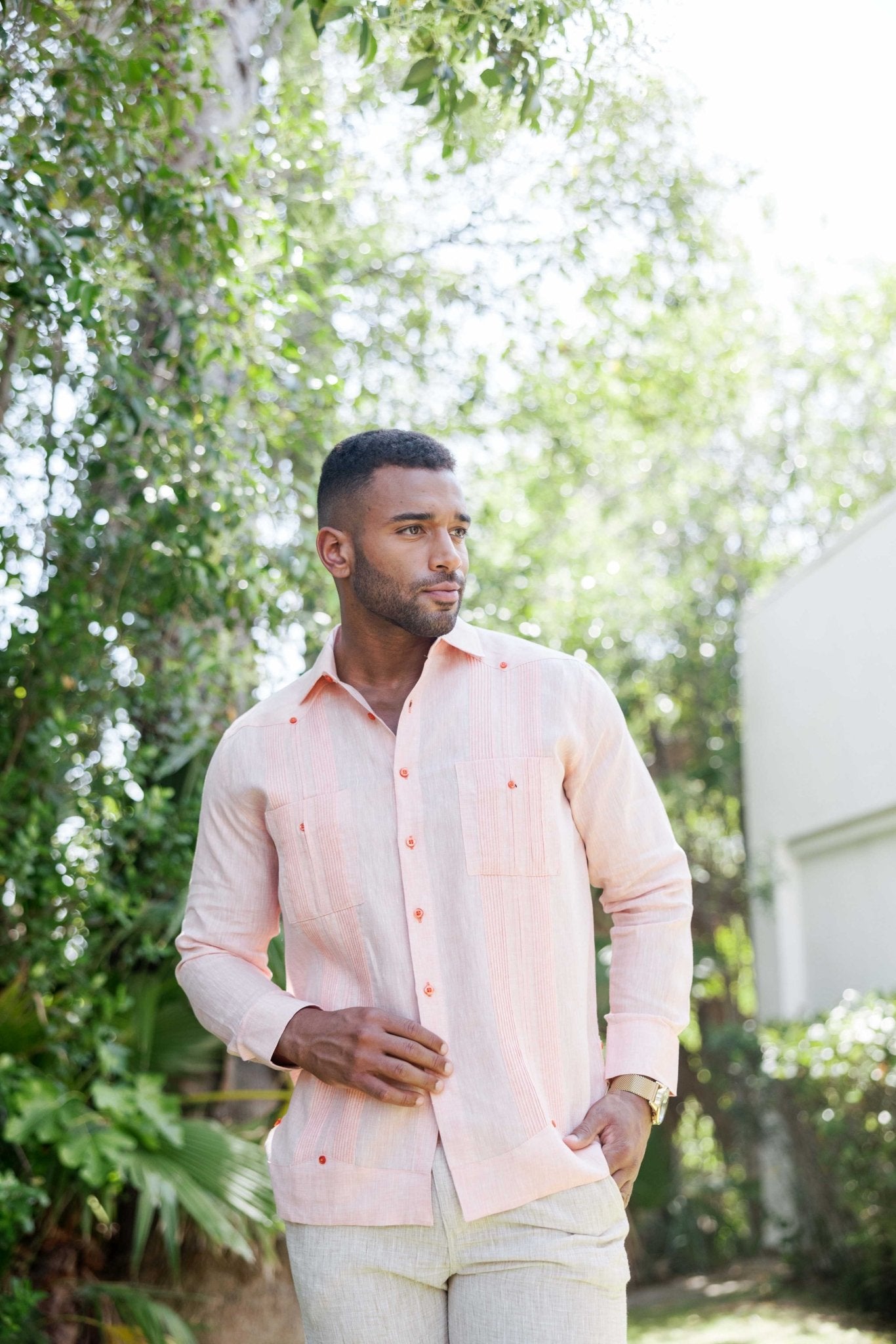 Man in a pink long-sleeved Men’s 100% Linen Guayabera Shirt, showing heritage pleats detail.