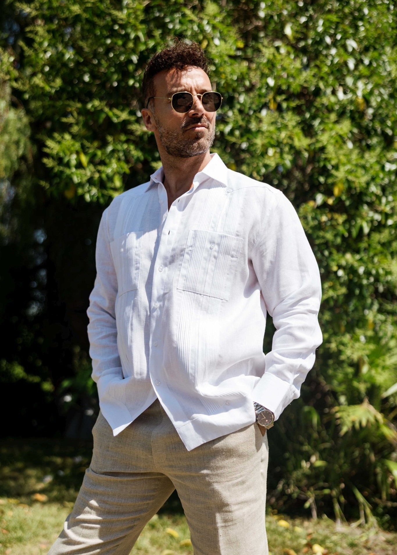 Man wearing a white long sleeve Men’s 100% Linen Guayabera Shirt, styled with pleats.