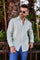 Man wears a light green, long-sleeved 100% Linen Contrast Panel Guayabera Shirt, sunglasses, and blue jeans.