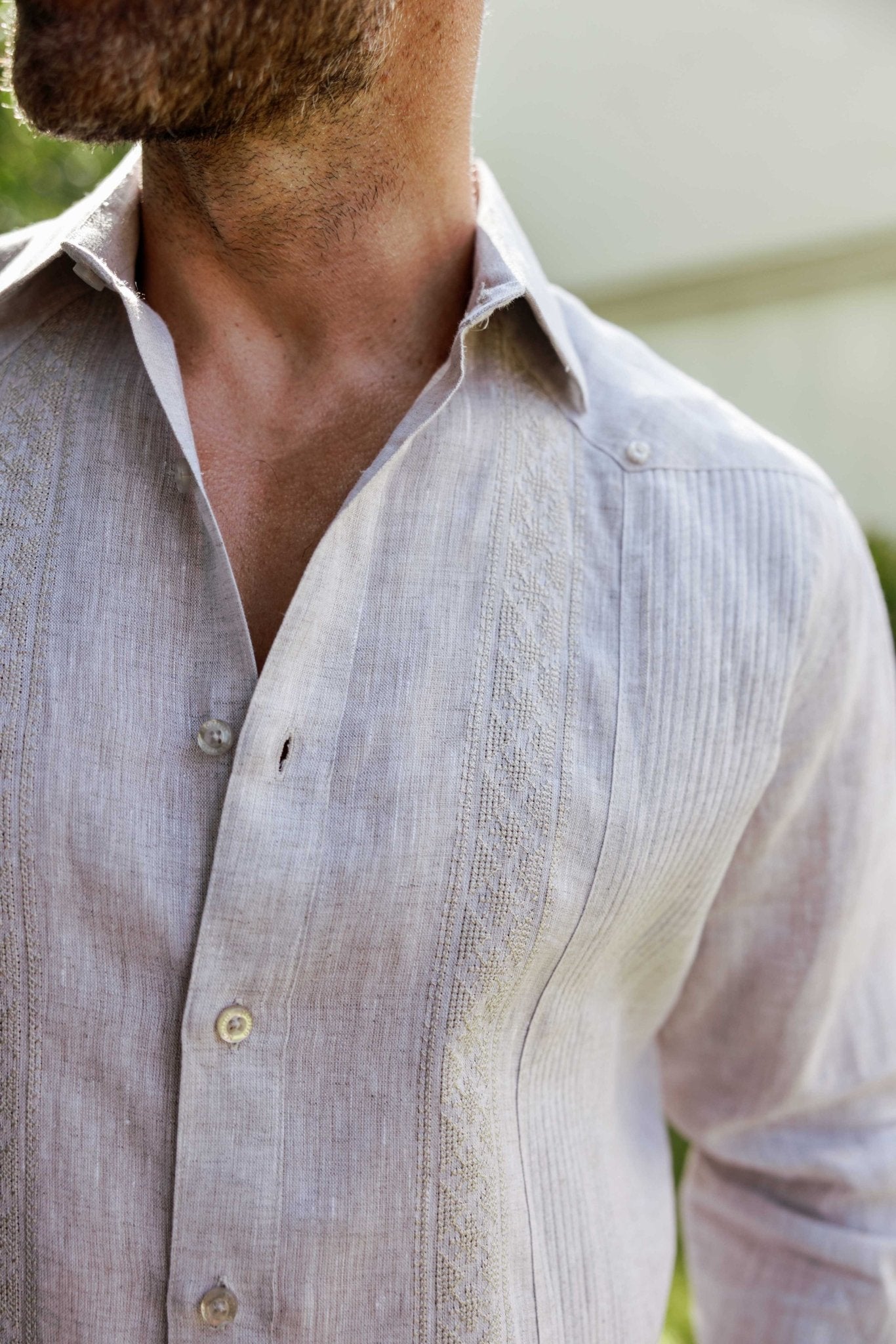 Close-up of an unbuttoned 100% Linen Contrast Panel Guayabera Shirt in tan, showing textural detail on the contrast panel.