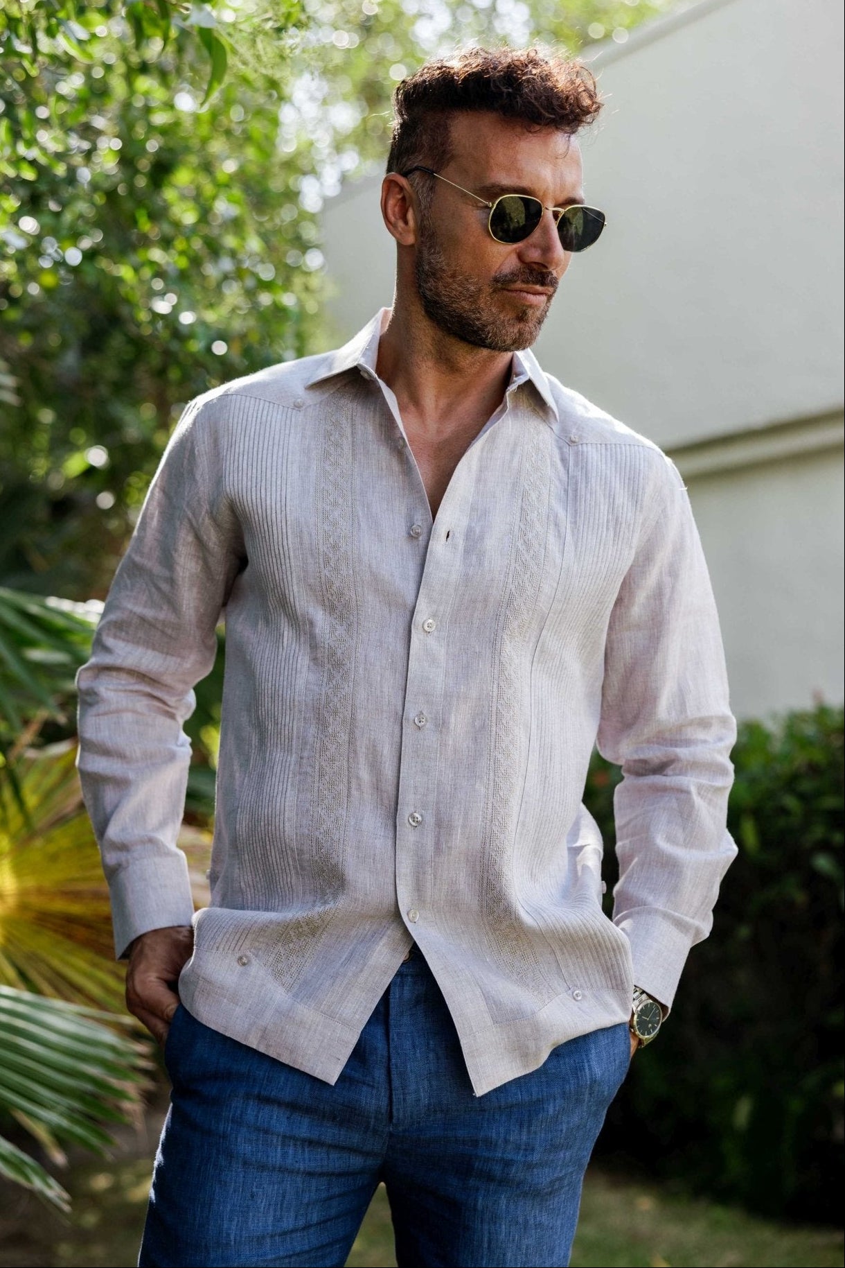 Man wearing a 100% Linen Contrast Panel Guayabera Shirt; long sleeves, light color with detailed contrast paneling.