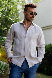 Man wearing a 100% Linen Contrast Panel Guayabera Shirt; long sleeves, light color with detailed contrast paneling.