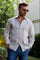 Man wearing a 100% Linen Contrast Panel Guayabera Shirt; long sleeves, light color with detailed contrast paneling.