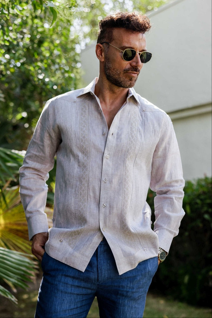 Man wearing a 100% Linen Contrast Panel Guayabera Shirt; long sleeves, light color with detailed contrast paneling.