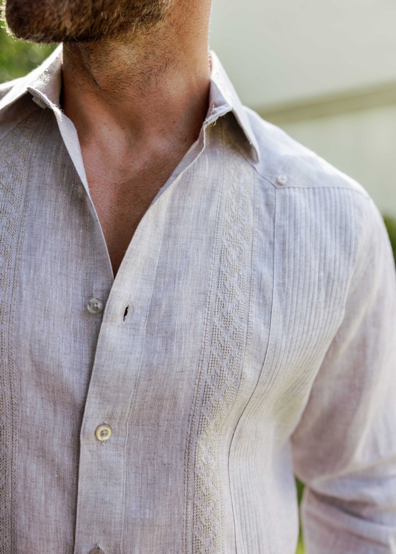 Close-up of an unbuttoned 100% Linen Contrast Panel Guayabera Shirt in tan, showing textural detail on the contrast panel.