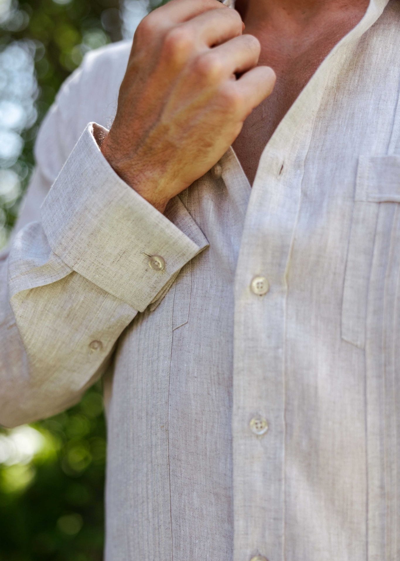 Detail view of the button cuff and premium linen texture on a tan men's long sleeve guayabera.