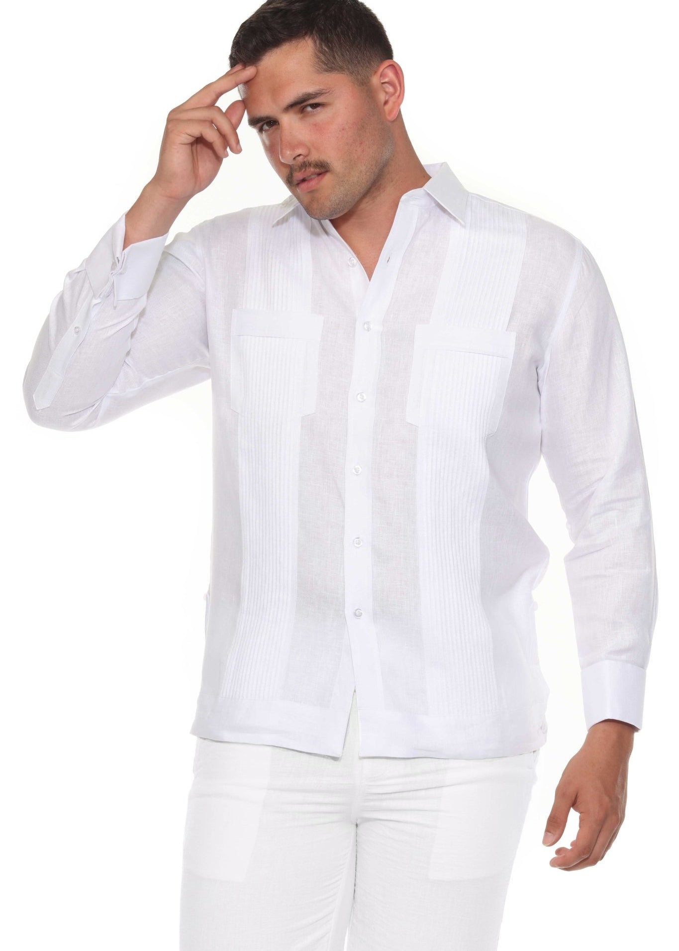 Full studio view of a man wearing the white 100% linen long sleeve guayabera with tonal pleats and white trousers.