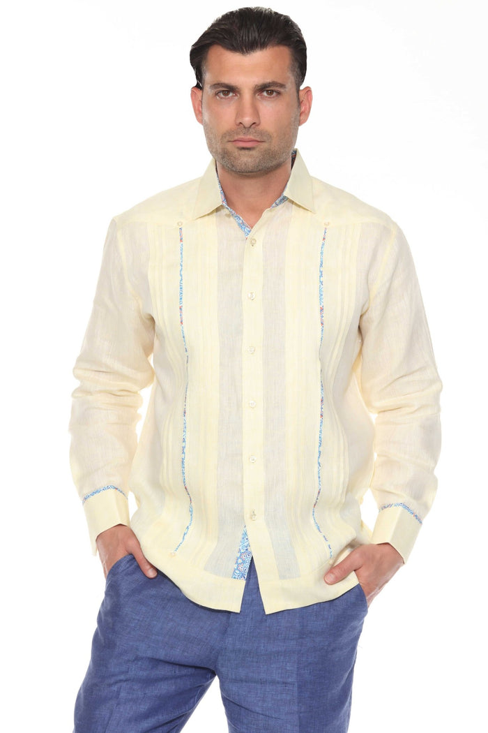 Man wearing a cream 100% linen long sleeve guayabera shirt with blue embroidery and signature pleated front.