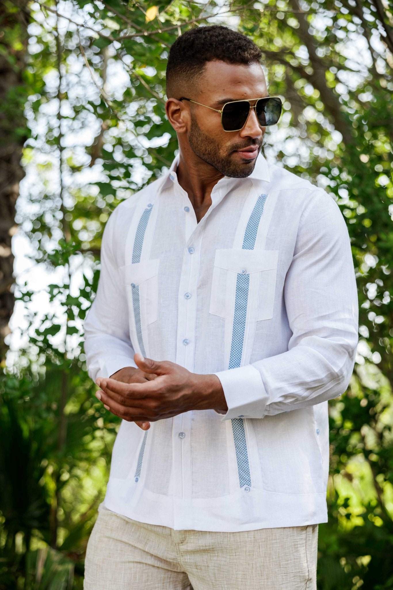 Man in a white linen long sleeve Guayabera shirt with artisan blue embroidery.