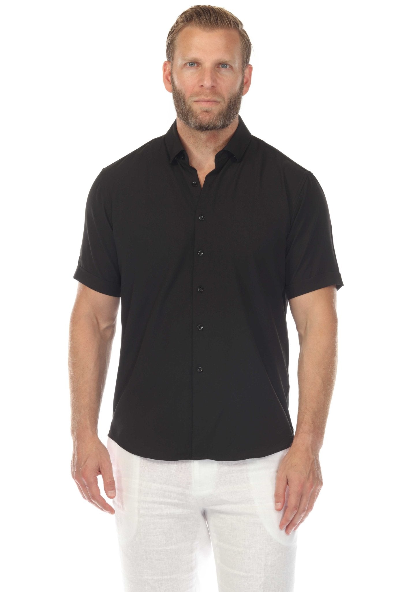 Front view of a man wearing a black Menâ€™s Classic 4-Way Stretch Short Sleeve Shirt with white pants.
