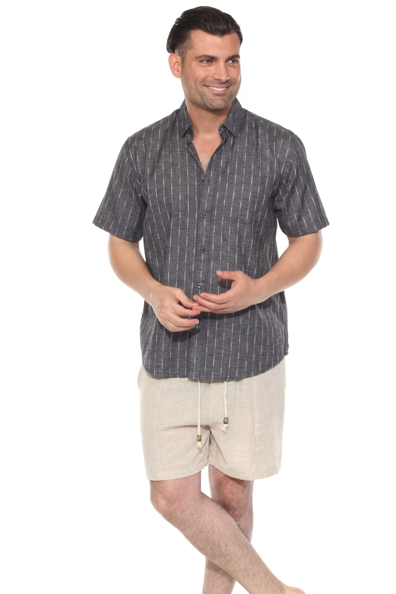 A man in a charcoal Men’s Pinstripe Resort Shirt with white stripes buttoned up, and beige shorts.