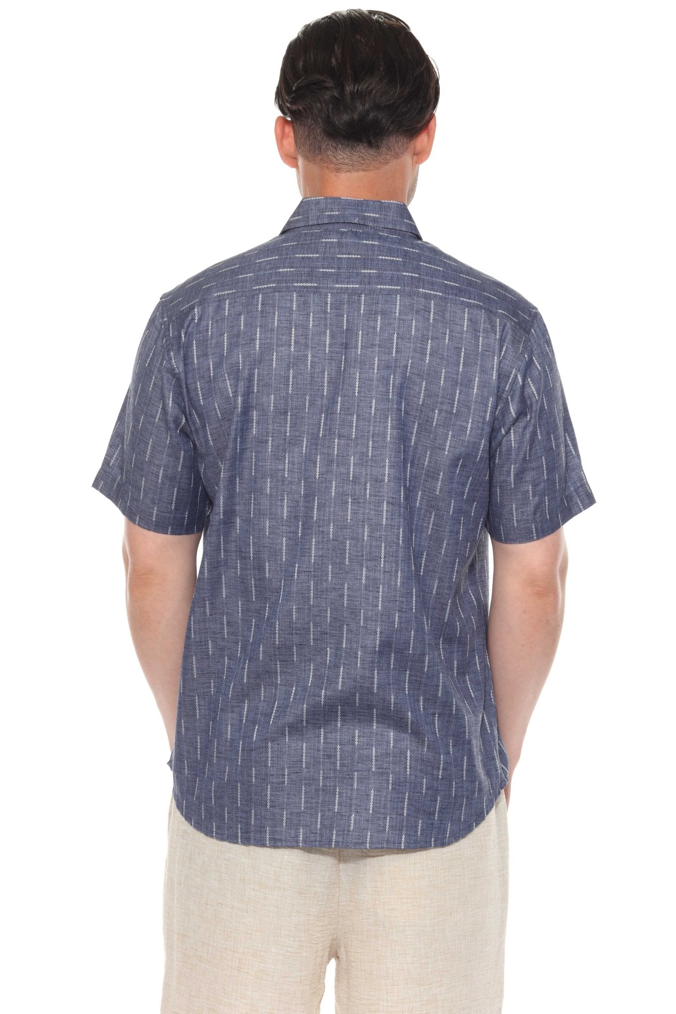 Back view of a man wearing the blue pinstripe resort shirt with short sleeves and khaki shorts.