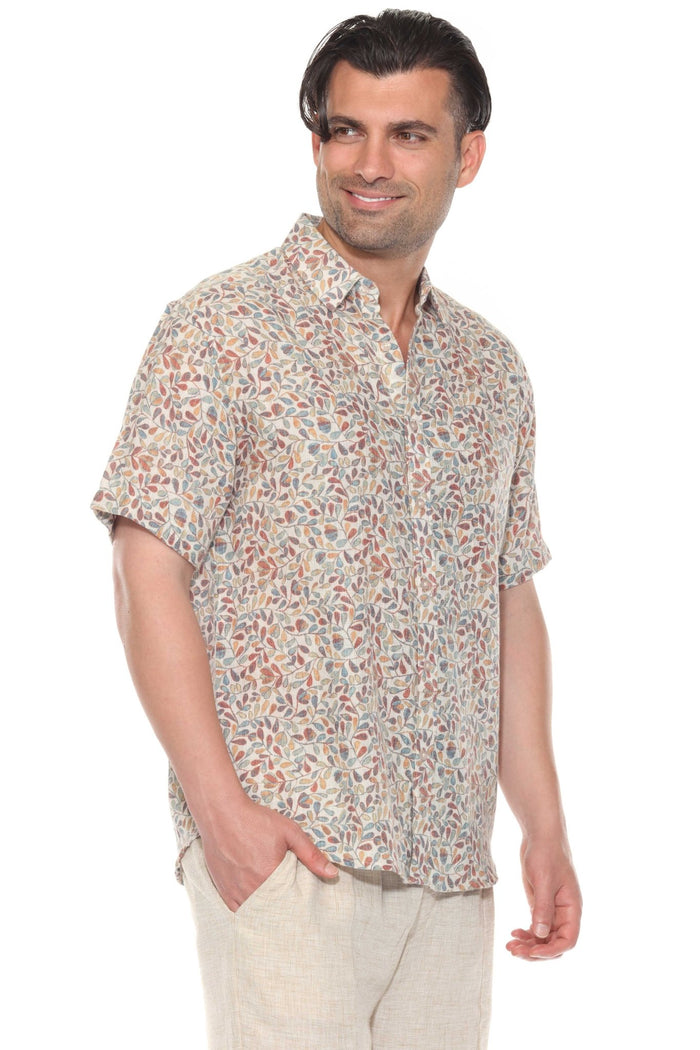 Man wears the gray resort print men's short sleeve button-up shirt outdoors, sunglasses on, looking off to the side.