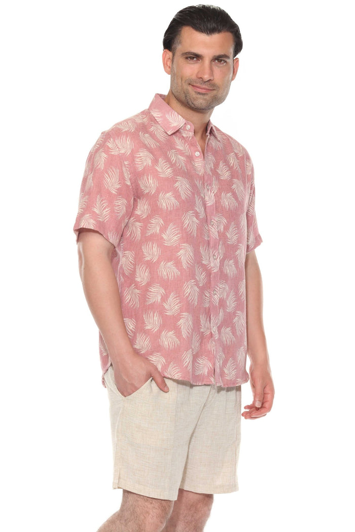 Man wears the gray resort print men's short sleeve button-up shirt outdoors, sunglasses on, looking off to the side.