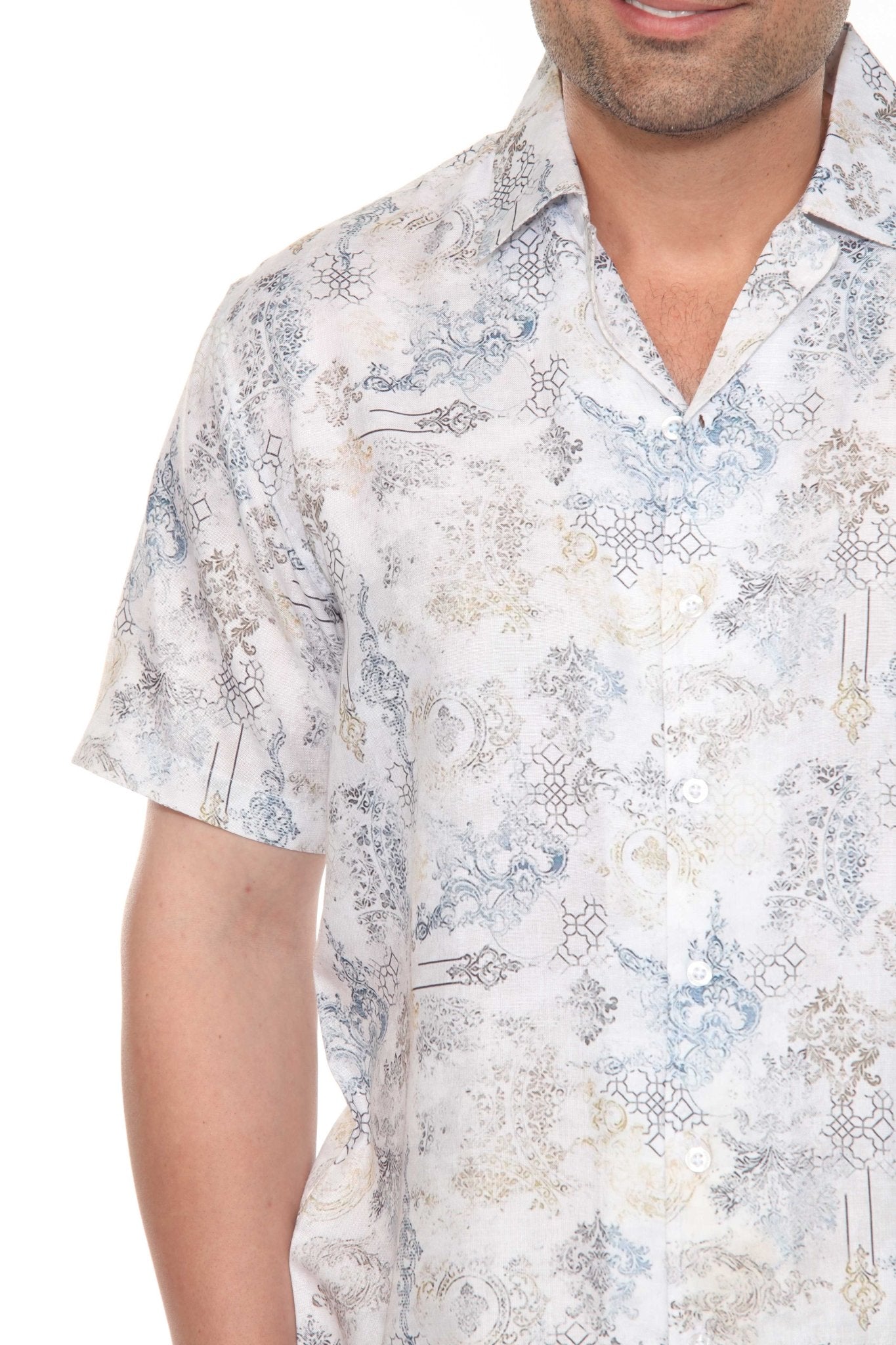 Close-up of a man wearing a Men’s Tropical Print Resort Shirt, which is a short sleeve button-up with a white, blue, and tan ornate pattern.