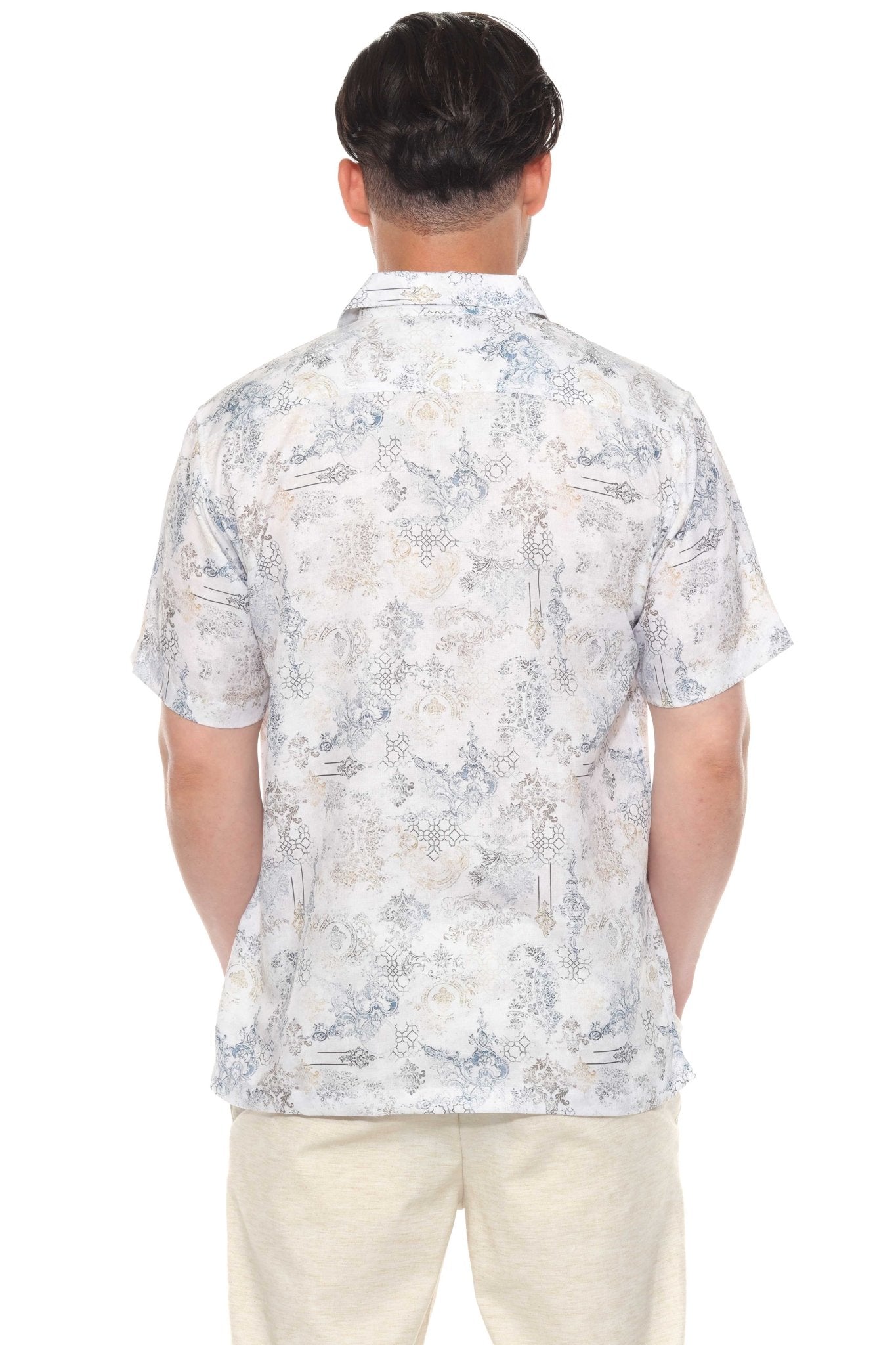 Back view of a man wearing the white-based tropical print Men’s Resort Shirt with short sleeves and button-up closure.
