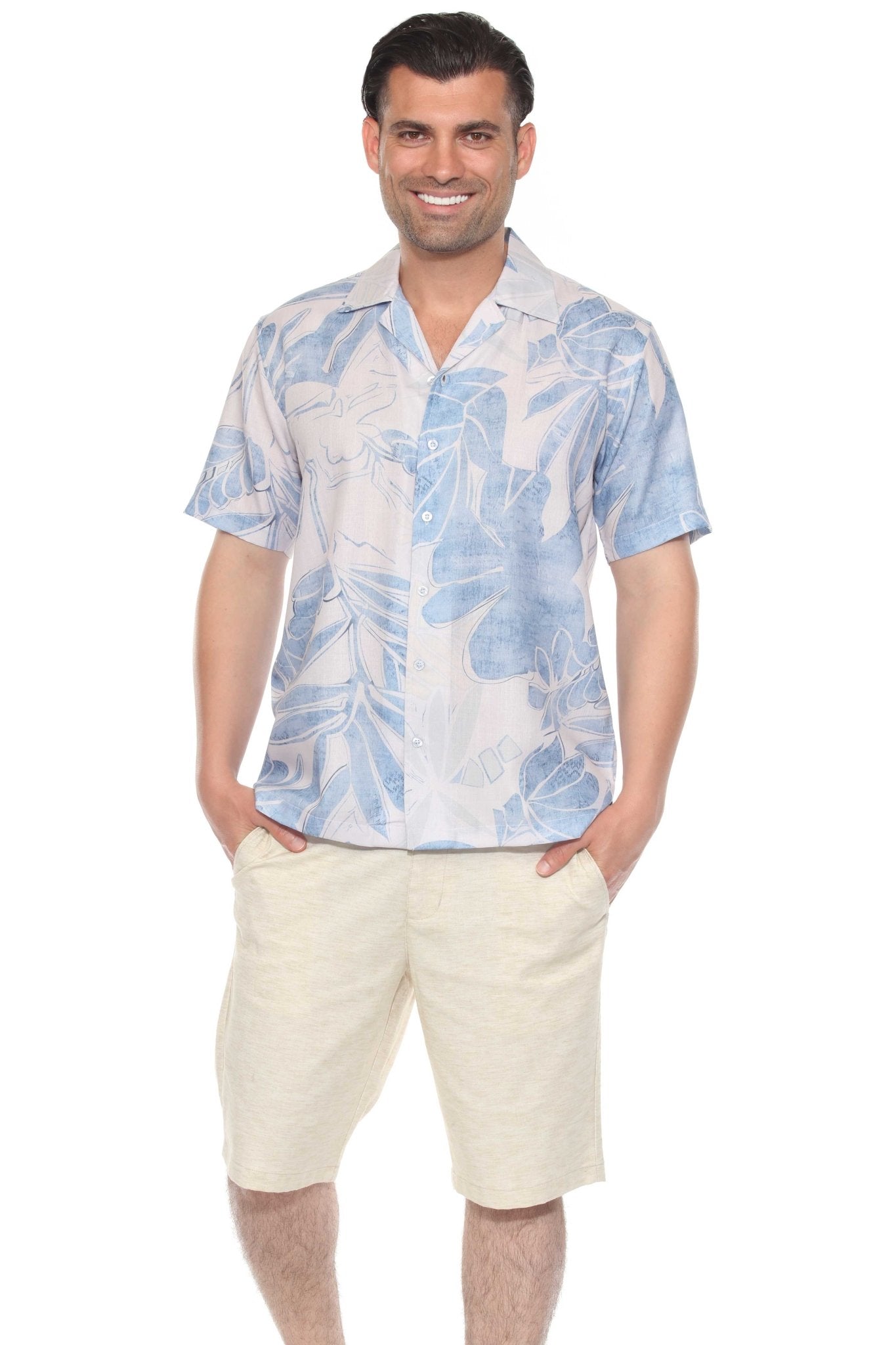 A man smiles wearing a Men’s Tropical Print Resort Shirt, white with a blue floral print, with khaki shorts.