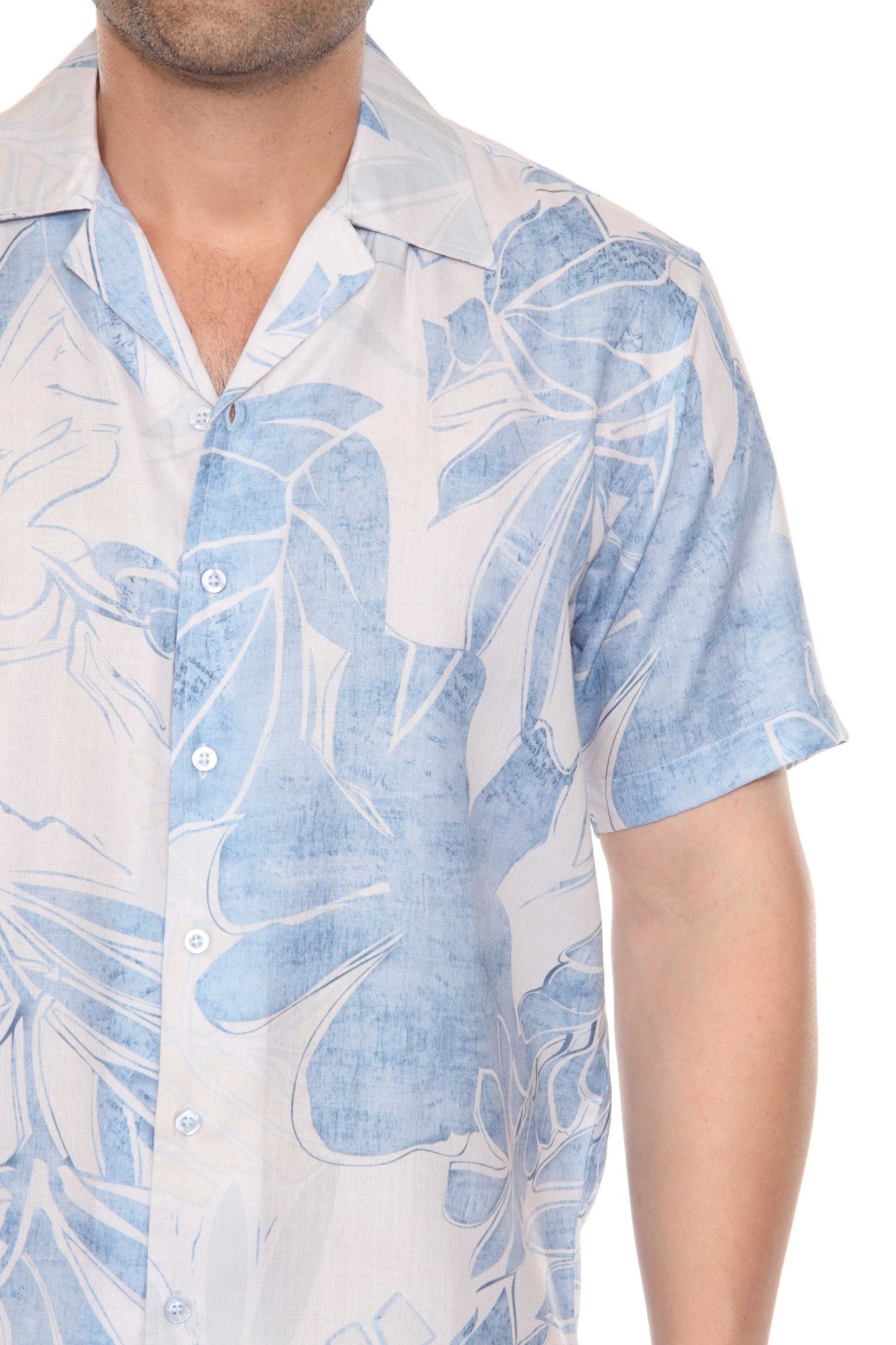 Close-up of a man wearing a light blue and white tropical print Men’s Resort Shirt, partially buttoned.