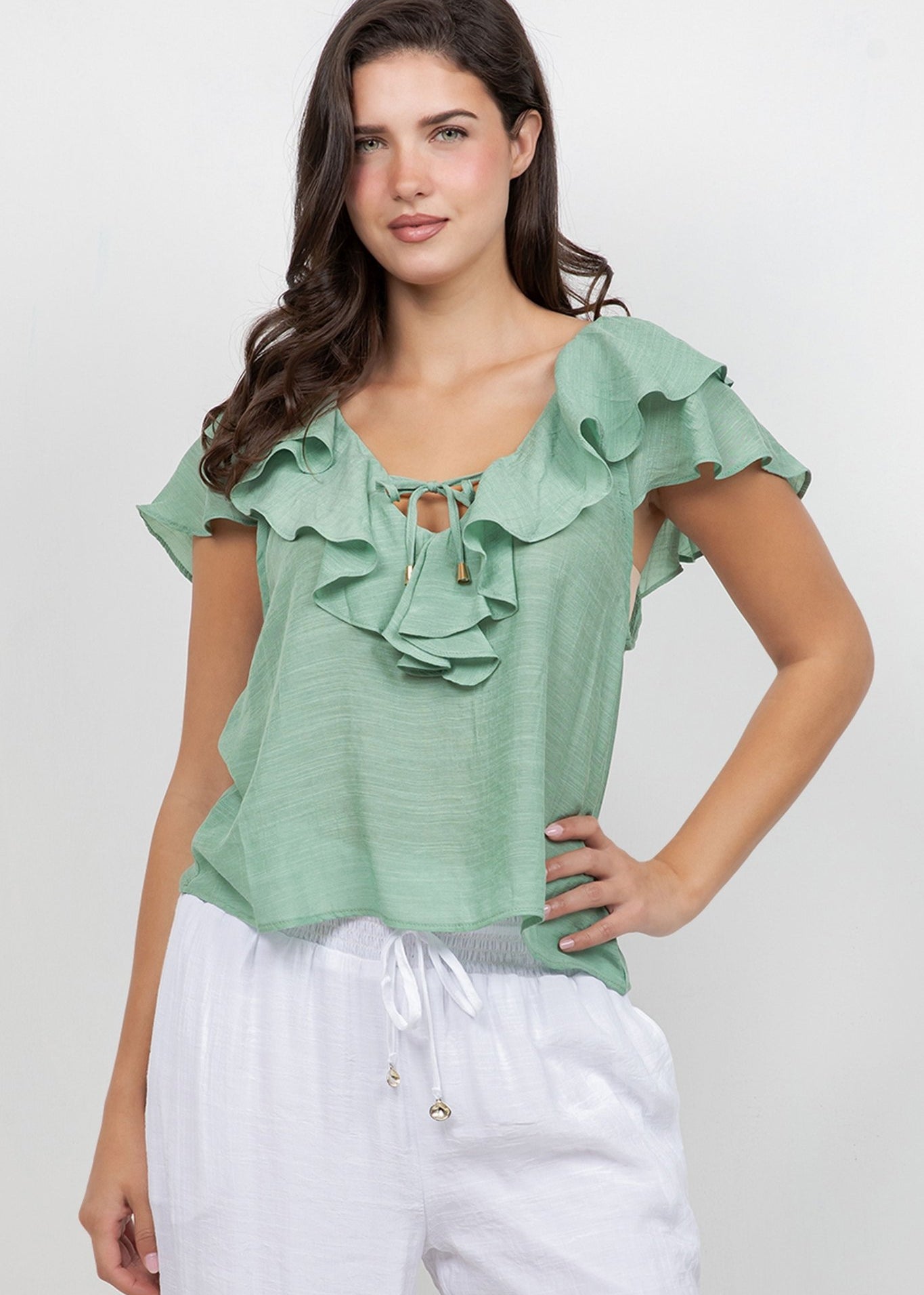 A woman models the Ladies Casual Boho Ruffled Tie Blouse in light green with ruffled detail.