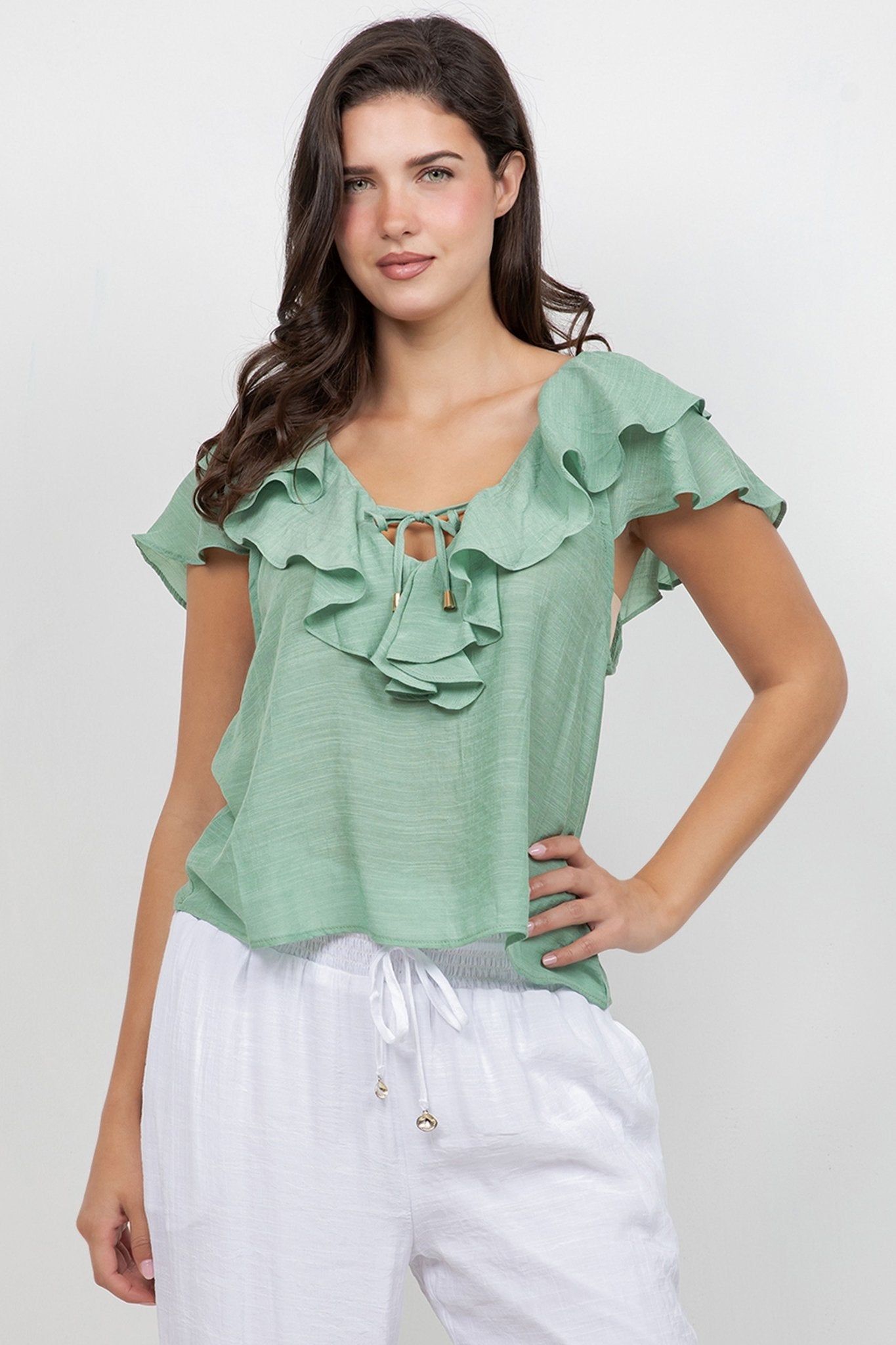 A woman models the Ladies Casual Boho Ruffled Tie Blouse in light green with ruffled detail.