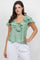A woman models the Ladies Casual Boho Ruffled Tie Blouse in light green with ruffled detail.