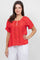 A woman wearing a red Ladies Boho Pleated Lace Panel Blouse with lace details.