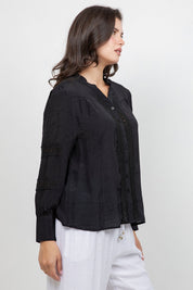 Profile of a woman wearing a black Ladies Boho Lace Panel Pleated Long Sleeve Blouse with lace trim detail.