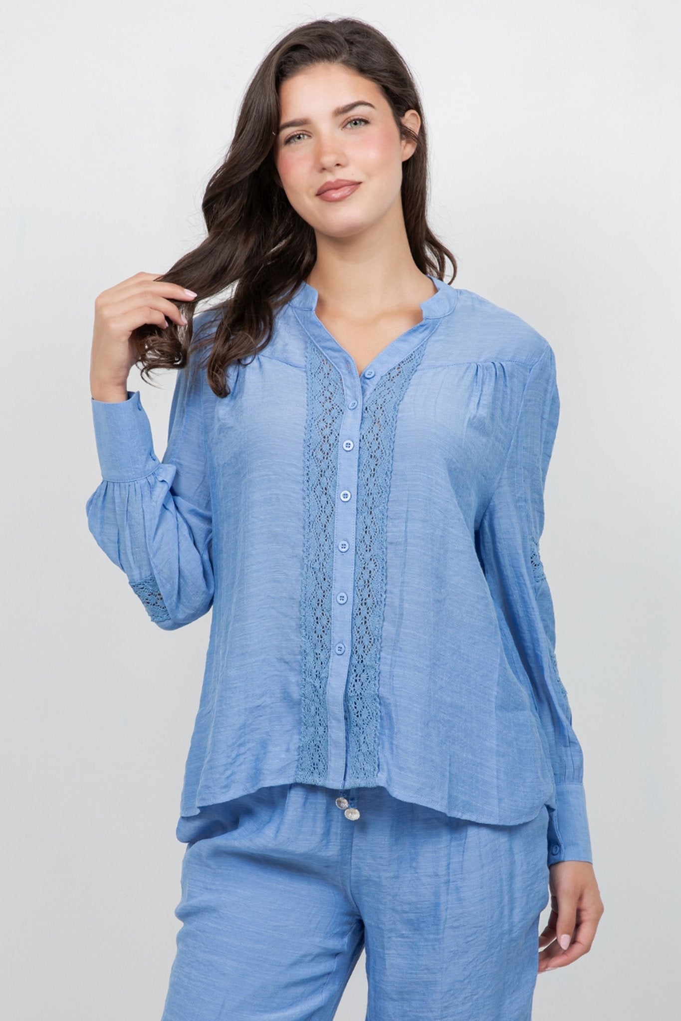 Woman models the light blue Ladies Boho Lace Panel Pleated Long Sleeve Blouse and matching pants.