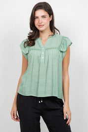 A woman models the Ladies Boho Flutter Sleeve Button Blouse in light green with lace detail.