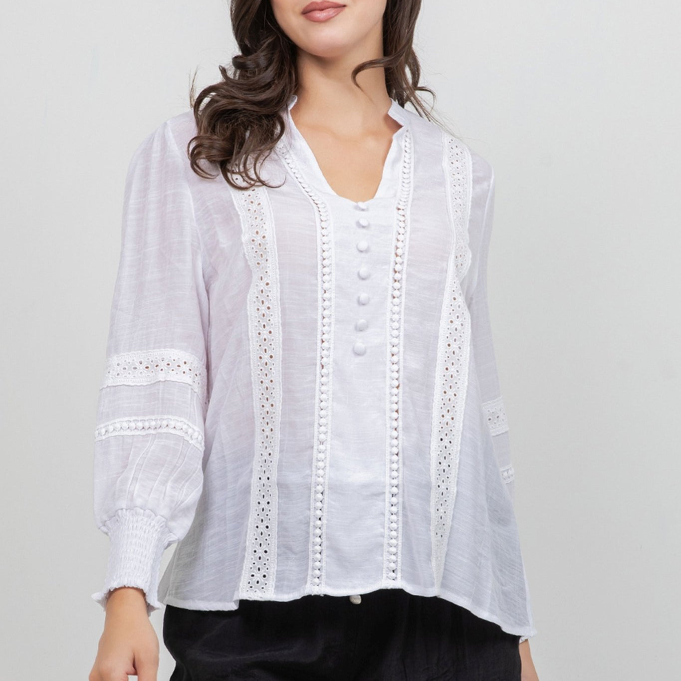 Front view of a woman wearing a white, button-down Ladies Boho Lace Panel Long Sleeve Blouse.
