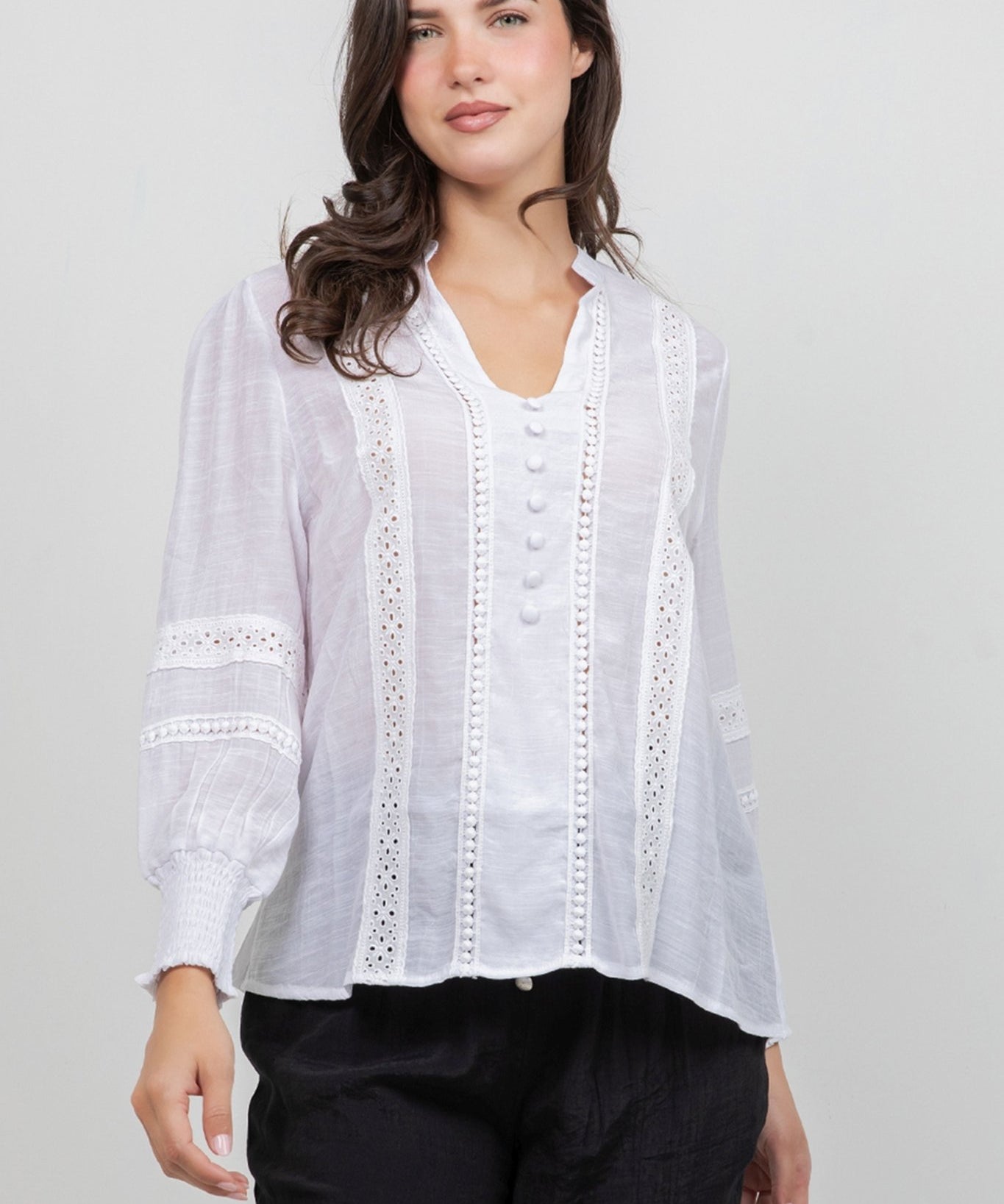 Front view of a woman wearing a white, button-down Ladies Boho Lace Panel Long Sleeve Blouse.