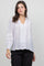 Front view of a woman wearing a white, button-down Ladies Boho Lace Panel Long Sleeve Blouse.