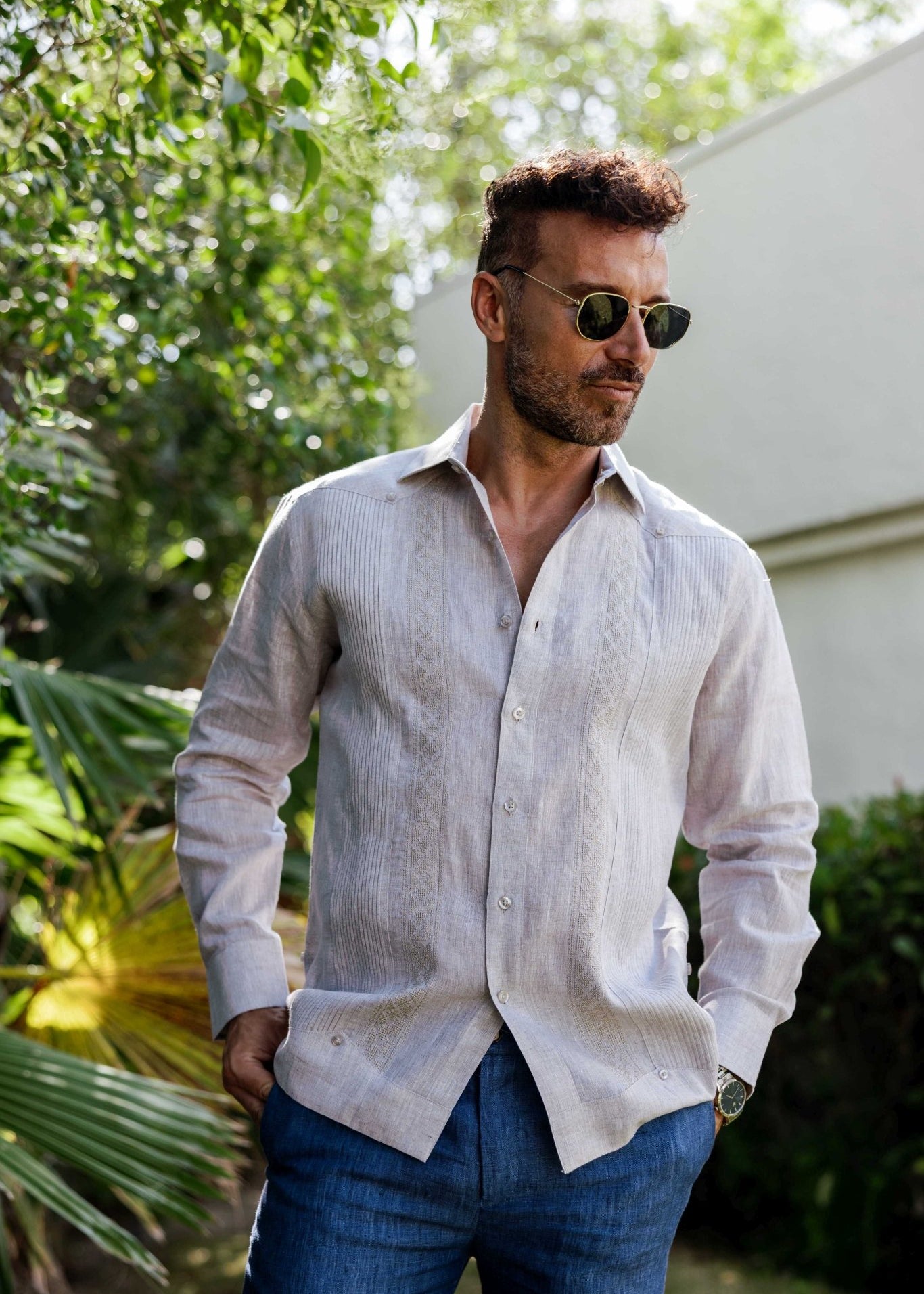 Man wearing a 100% Linen Contrast Panel Guayabera Shirt; long sleeves, light color with detailed contrast paneling.
