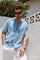 Angled view of a man wearing a blue Striped Linen Blend Resort Shirt with white pants.