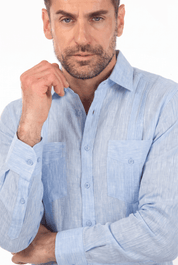 Close-up of a man wearing a light blue, buttoned, long-sleeve Irish Linen Four Pocket Guayabera Shirt.