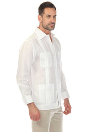 A man models a white, long-sleeved Irish Linen Four Pocket Guayabera Shirt, shown at a slight angle.