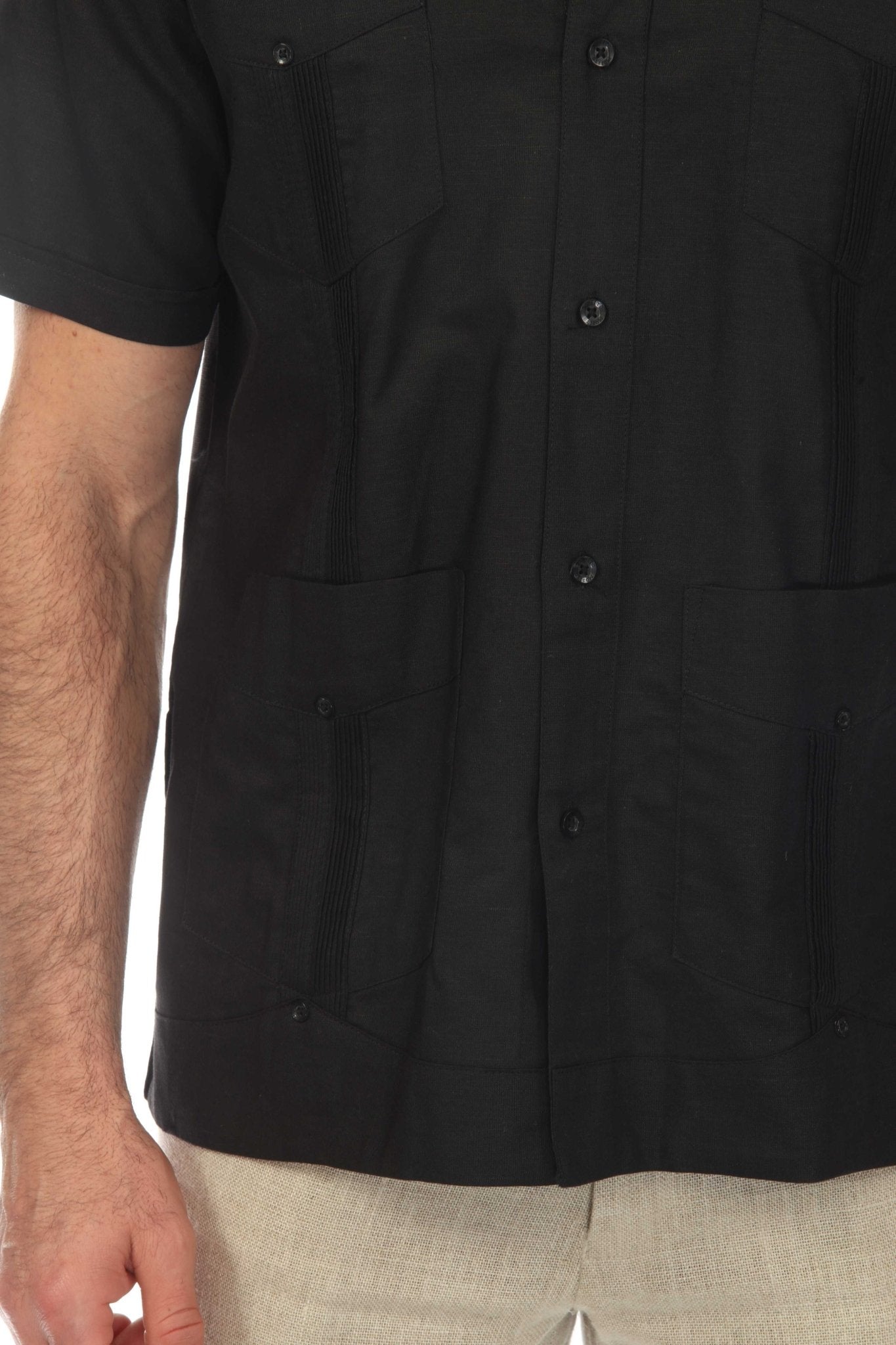 Close view of a model wearing the black linen Guayabera shirt, showing the pockets, buttons, and classic details.