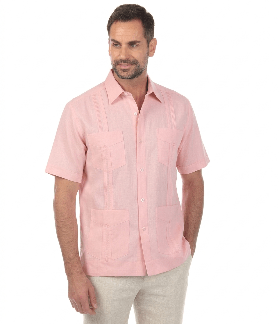 Men's light pink linen guayabera shirt showing the breathable fabric and authentic four-pocket styling for warm weather.