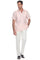 Men’s light pink short sleeve guayabera shirt in premium linen, styled with white trousers for resort wear.