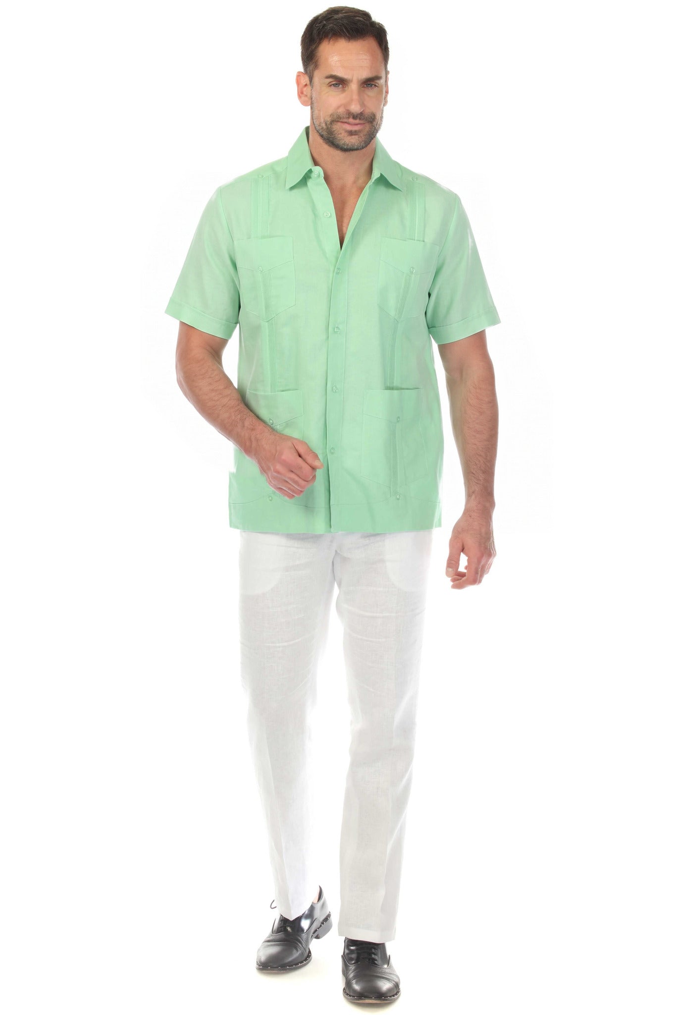 Front view of a men's mint green short sleeve 100% linen guayabera shirt with four pockets and vertical pleats, worn with white linen trousers.