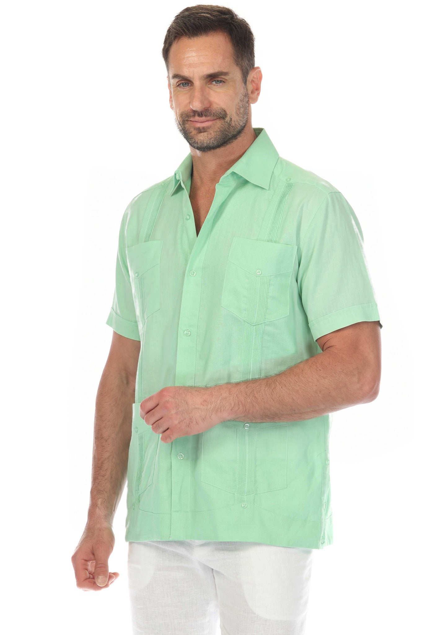 Three-quarter view of the mint green short sleeve linen guayabera shirt showing the collar, pleats and flap pockets.