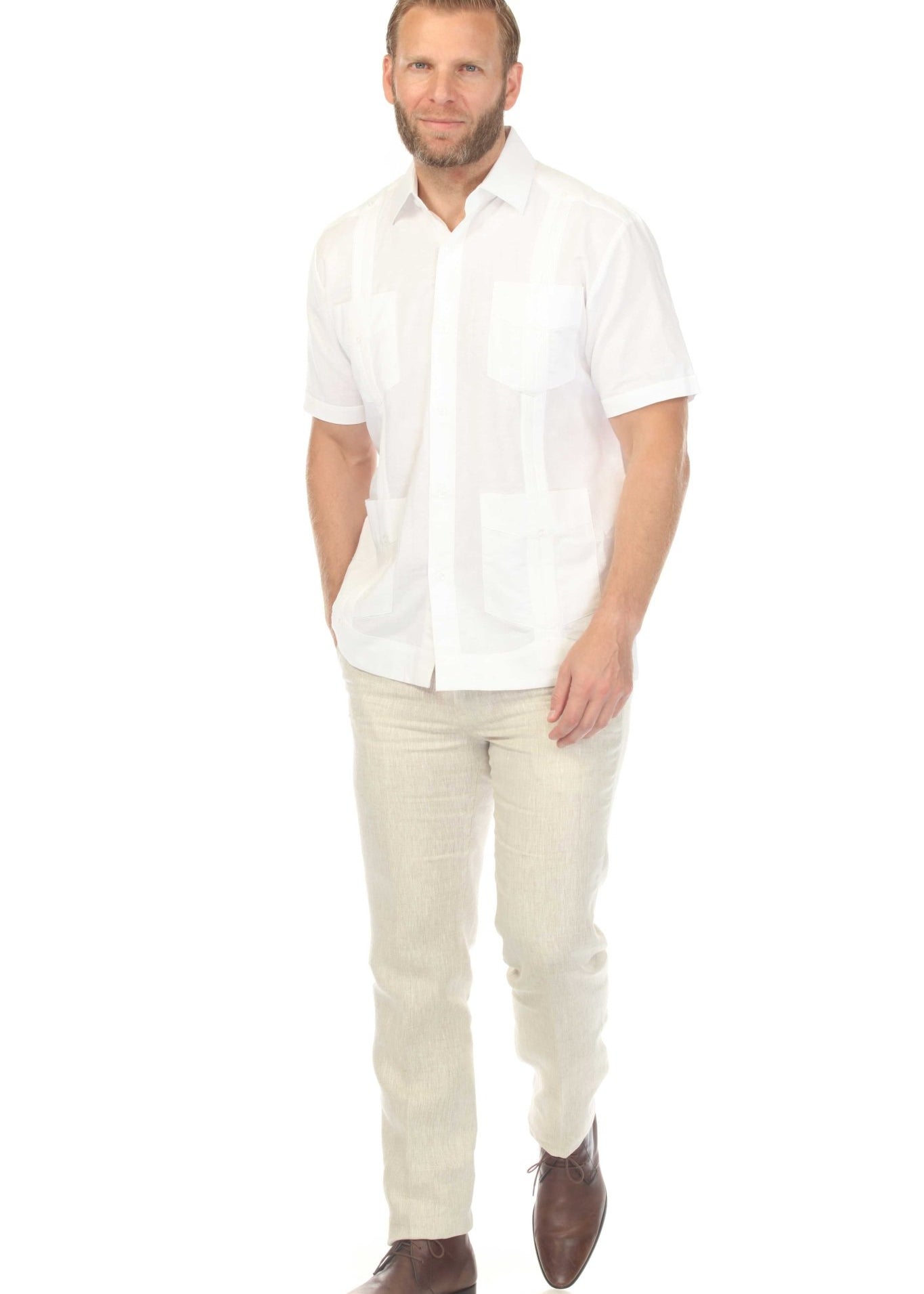 A man walks towards the viewer wearing a white, short-sleeved Men's 100% Linen Classic Guayabera Shirt.