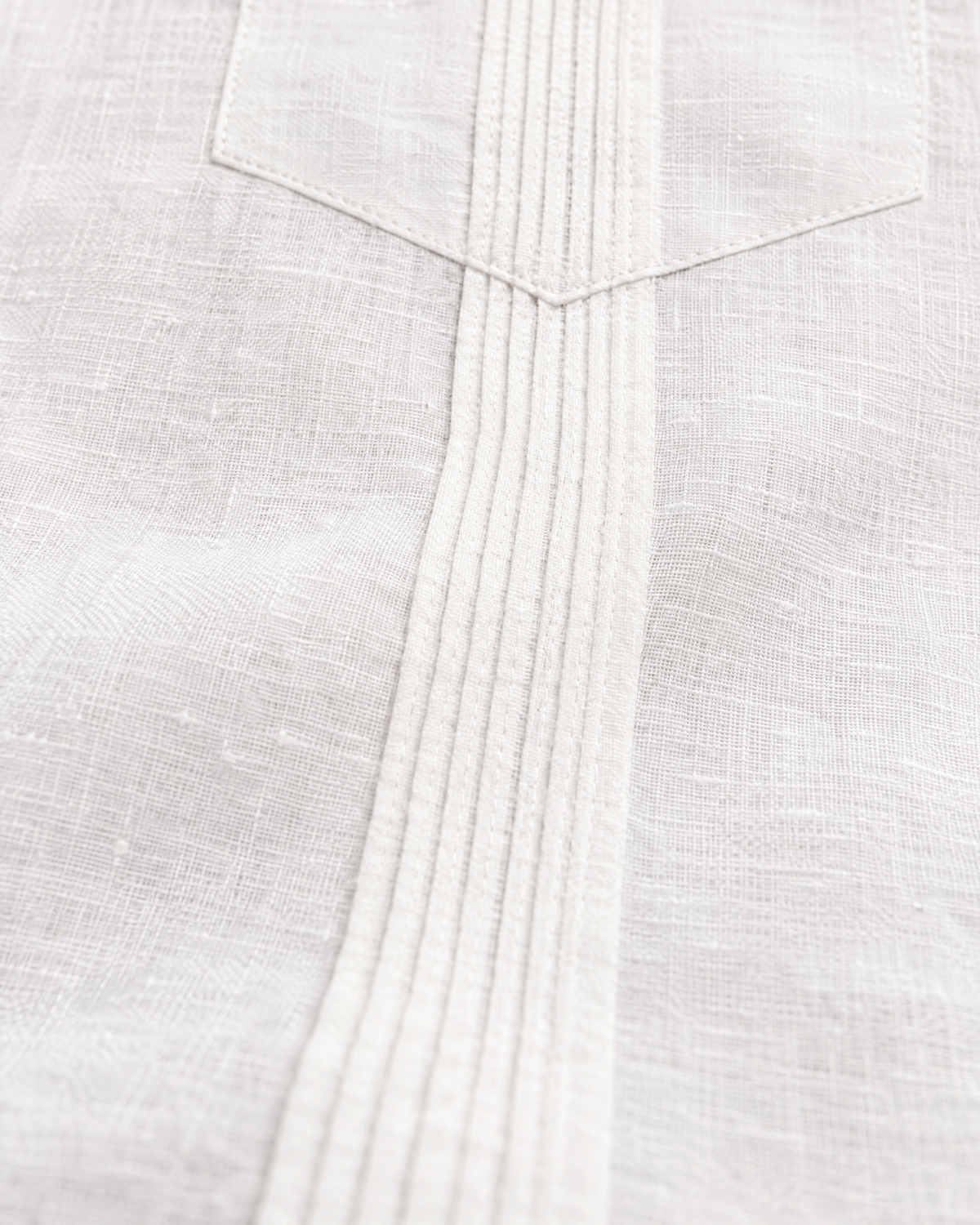 Macro of the alforza pin-tuck pleats below the pocket point on the white linen guayabera