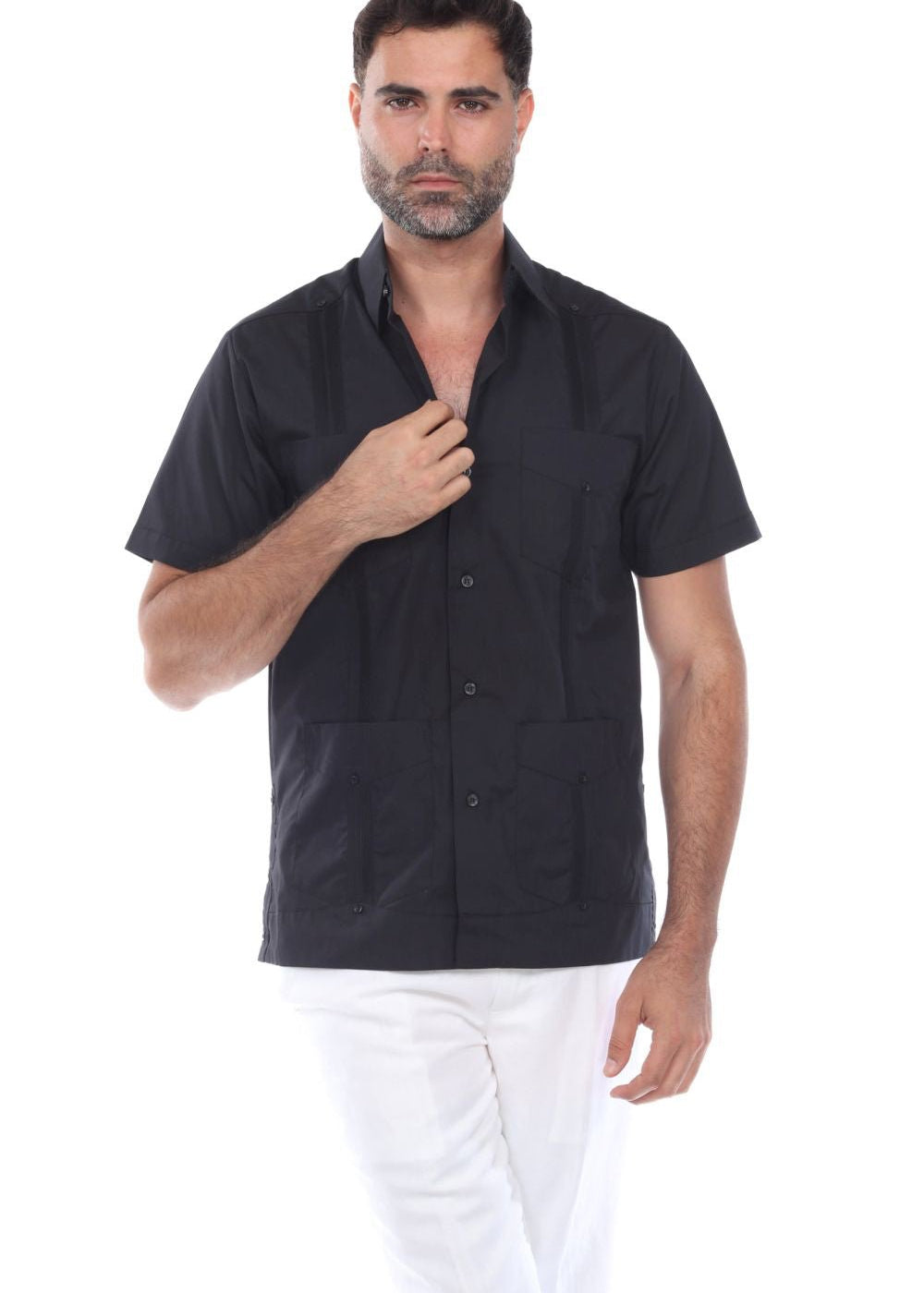 A man wearing a black short sleeve guayabera shirt with white pants, showcasing a sharp and comfortable summer resort style.