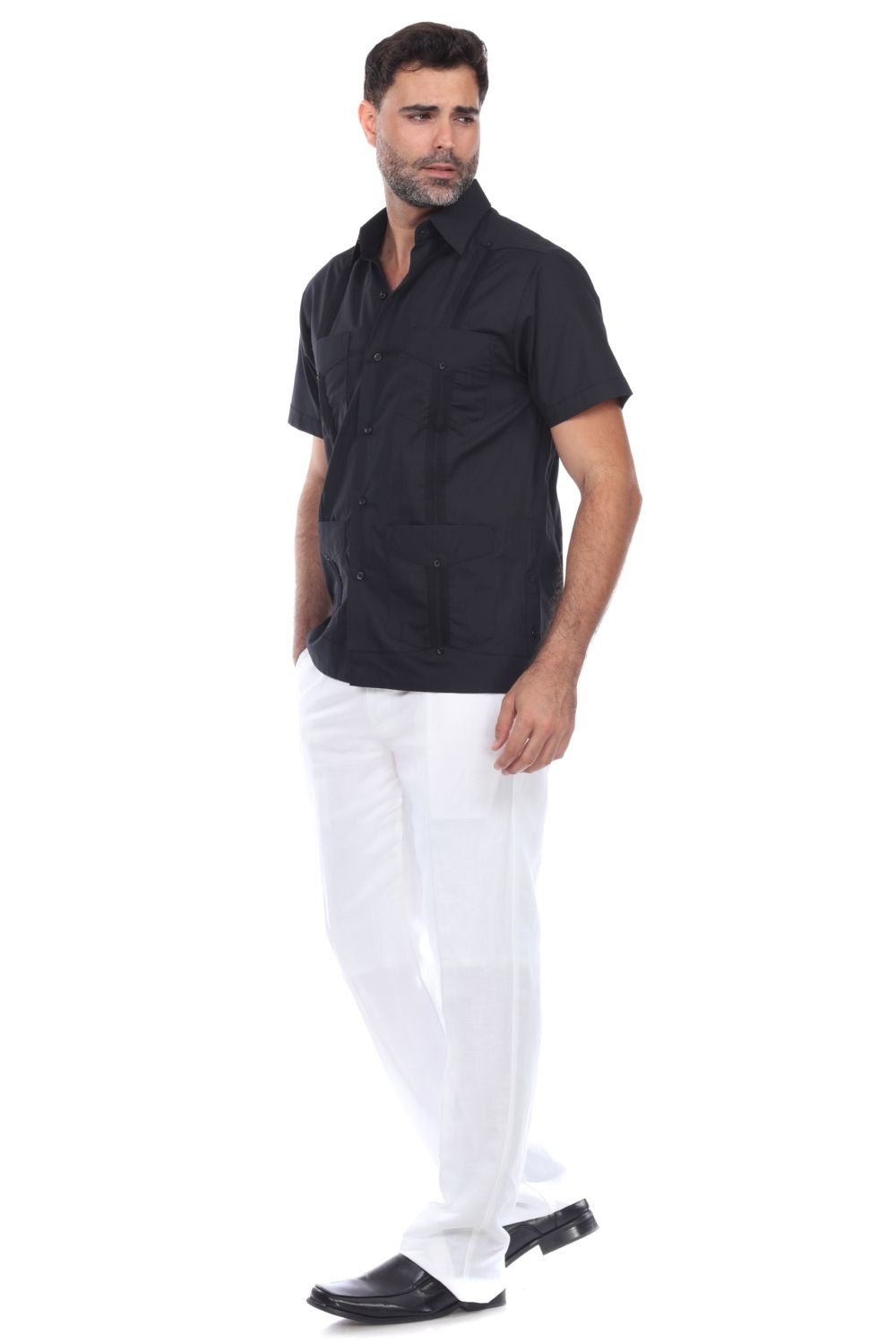 Full body view of a man in a black guayabera shirt and white trousers, perfect for weddings or everyday polish.