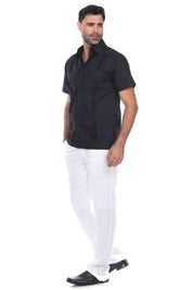 Full body view of a man in a black guayabera shirt and white trousers, perfect for weddings or everyday polish.